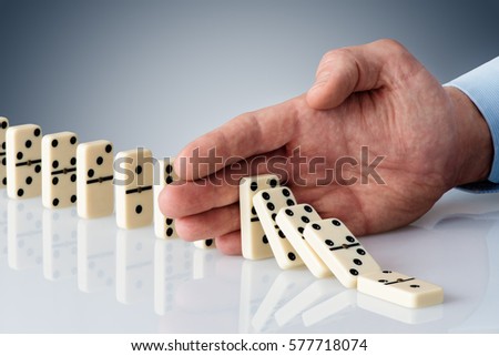 hand stopping domino falling sequence