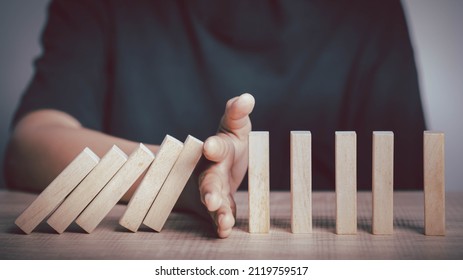 Hand Stopping Wooden Domino Business Crisis Effect Or Risk Protection Concept. Management And Insurance, Business Solution And Intervention.