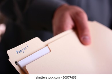 The hand stretches a folder with documents for the project.