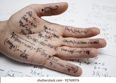 Hand of student with cheat sheet for math exam - selective focus