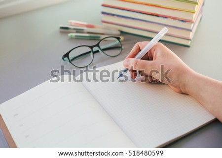 Hand of student studying and writing in notebook