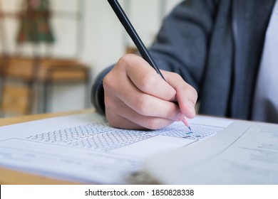 Hand Student Use Pencil Writing On Paper Optical Form Of Standardized Test Examination, Answer Sheet,doing Final Exam Attending In Examination Classroom