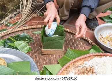 Hand stuffing Chung Cake in square shape with glutinous rice, split mung beans, chunks of pork shoulder, salt, pepper, ginger. It is packed as tight as possible to keep cake from mold or spoiled.
