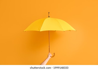 Hand with stylish umbrella on color background - Shutterstock ID 1999148333