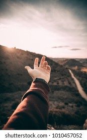 hand with a sunset in the top of the mountain