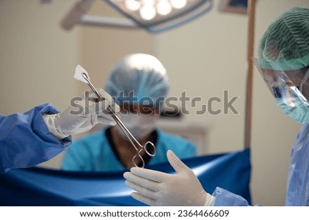Hand of surgery doctor in Operating Room hold operating plier forceps tweezer with gauze give to Surgeons During Operation. operating tool clamp plier forceps tweezer for pinch gauze ストックフォト © 