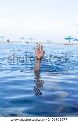 Hand in swimming pool water, Drown concept