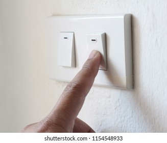 hand switching light power switch on or off.