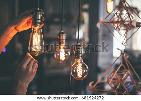Hand switching off the light bulbs, vintage light bulbs at coffee shop, vintage film look