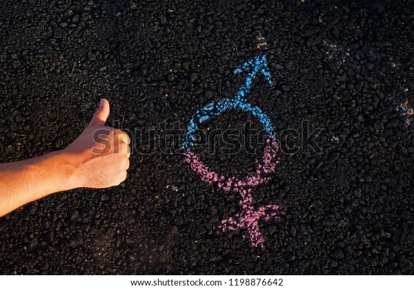 The hand with the symbol of gender\
equality on the pavement, the concept of gender.\
Man