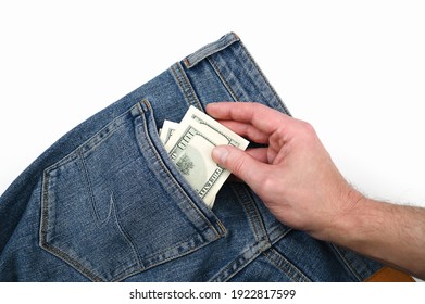 Hand Takes Dollar Bills In The Back Pocket Of Jeans. High Quality Photo