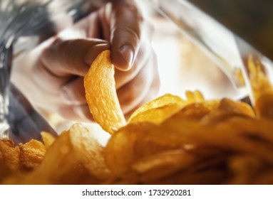 Hand Takes Out Potato Chips Inside The Package