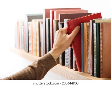 Hand Taking Book From The Shelf.