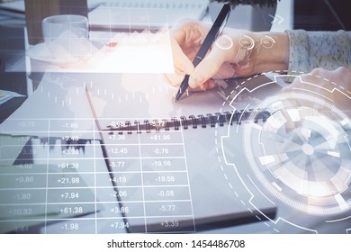 Hand taking notes in notepad. Forex chart holograms in front. Concept of research. Double exposure