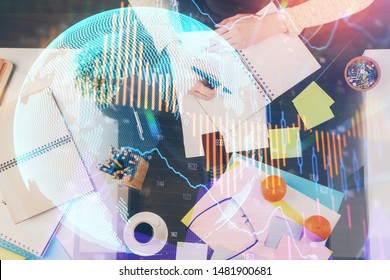 Hand taking notes in notepad. Forex chart holograms in front. Concept of research. Double exposure