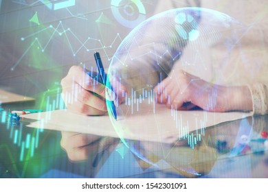 Hand taking notes in notepad. Forex chart holograms in front. Concept of research. Multi exposure