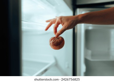 
Hand Taking out a Rotten Apple from the Fridge 
Person throwing away some damaged foods from a broken refrigerator 
