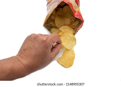 A Hand Taking Potato Chips From A Bag Of Potato Chips, Open And Front View. With Potato Chips Inside And Outside The Bag. Isolated On White Background. Selective Focus. 