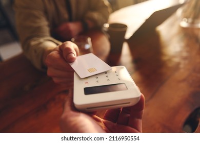 Hand Tapping A Credit Card On A Contactless Card Reader Paying For Coffee In Coffee Shop