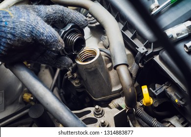 Hand of Technical checking  Engine oil , open and holding Car Engine Oil Filler Cap at garage .car maintenance and service and repair concept . selective focus .  - Shutterstock ID 1314883877