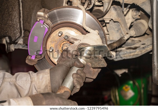A hand technical specialist repairing the brake\
system of the modern car.