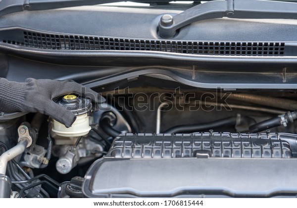 Hand\
of Technician checking brake fluid  in engine room maintenance and\
basic service concept of the car and brake system\
