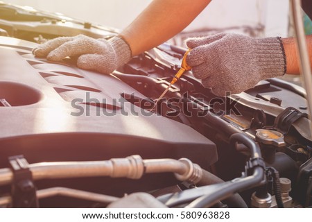 Hand of technician checking or fixing engine of modern car