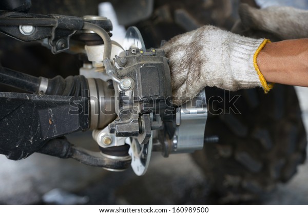 Hand of technician fixing\
the car
