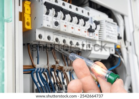 Hand Testing Electrical Circuit with Voltage Tester