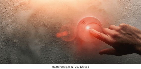 Hand Testing A Home Smoke Alarm Detector