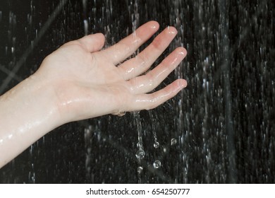 Hand Testing The Temperature Of Water In Shower