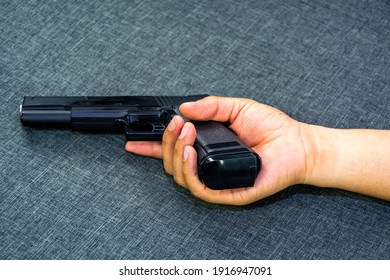 The hand that holds the gun for suicide or murder is on the sofa