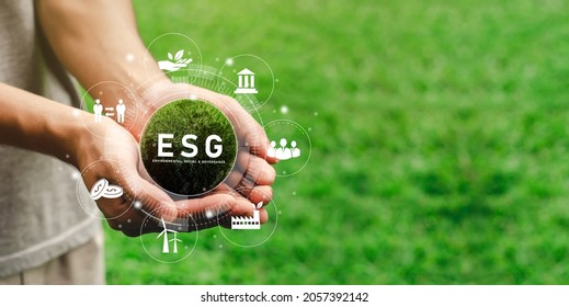 The hand that holds the world ready to use the technology of renewable resources to reduce pollution. In concept icon ESG in hand for the environment, society and sustainable business governance.