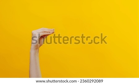 Hand theater. News advertisement. Female woman arm mouth gesture talking fun performance introducing sensation isolated on yellow background empty space.