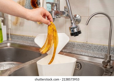 Hand Throwing Banana Peel In Food Waste Bin.