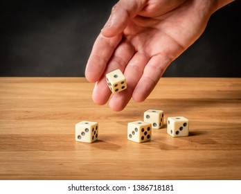 Hand throwing dice in front of a black background. - Shutterstock ID 1386718181