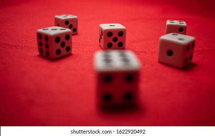 Hand Throwing Dice, Hoping For The Best Odds. Six Dice On Red Background