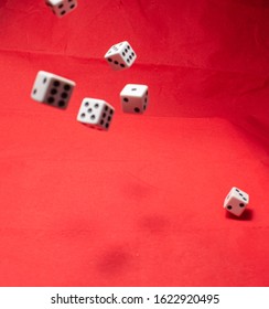 Hand Throwing Dice, Hoping For The Best Odds. Six Dice On Red Background