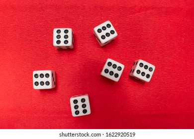 Hand Throwing Dice, Hoping For The Best Odds. Six Dice On Red Background