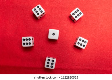 Hand Throwing Dice, Hoping For The Best Odds. Six Dice On Red Background