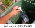 Hand throwing empty plastic bottle into recycle garbage trash.