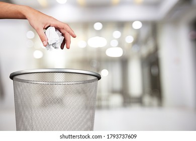 Hand Throwing Out Paper Into A Trash Basket