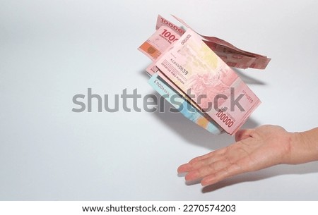 hand throwing pile of rupiah (idr) banknotes on white background. Saving Indonesian Rupiah. Financial Concept.