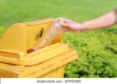 Hand Throwing Plastic Water Bottle In Recycle Bin