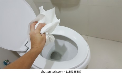 Hand Throwing Tissue Paper Directly In The Toilet Bowl.