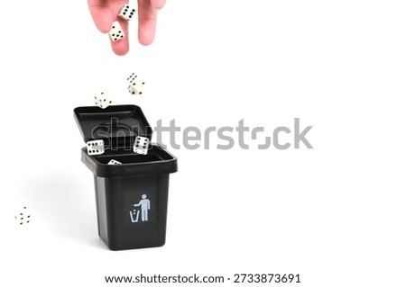 Hand throws dice into trash can. Concept of non gambling