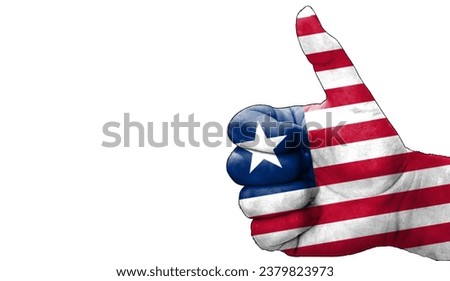 hand with thumbs up in approval with the Liberian flag painted. Image with empty white background copy space area