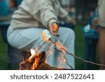 hand toasting smores on campfire