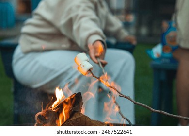 hand toasting smores on campfire - Powered by Shutterstock