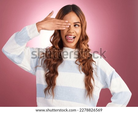 Hand, tongue out and woman in studio, silly and having fun against red background. Face, emoji and gen z girl model posing, young and confident, playful and goofy, casual and comic while isolated